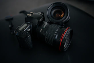 black Canon DSLR camera beside camera lens