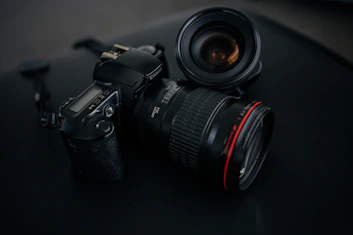black Canon DSLR camera beside camera lens
