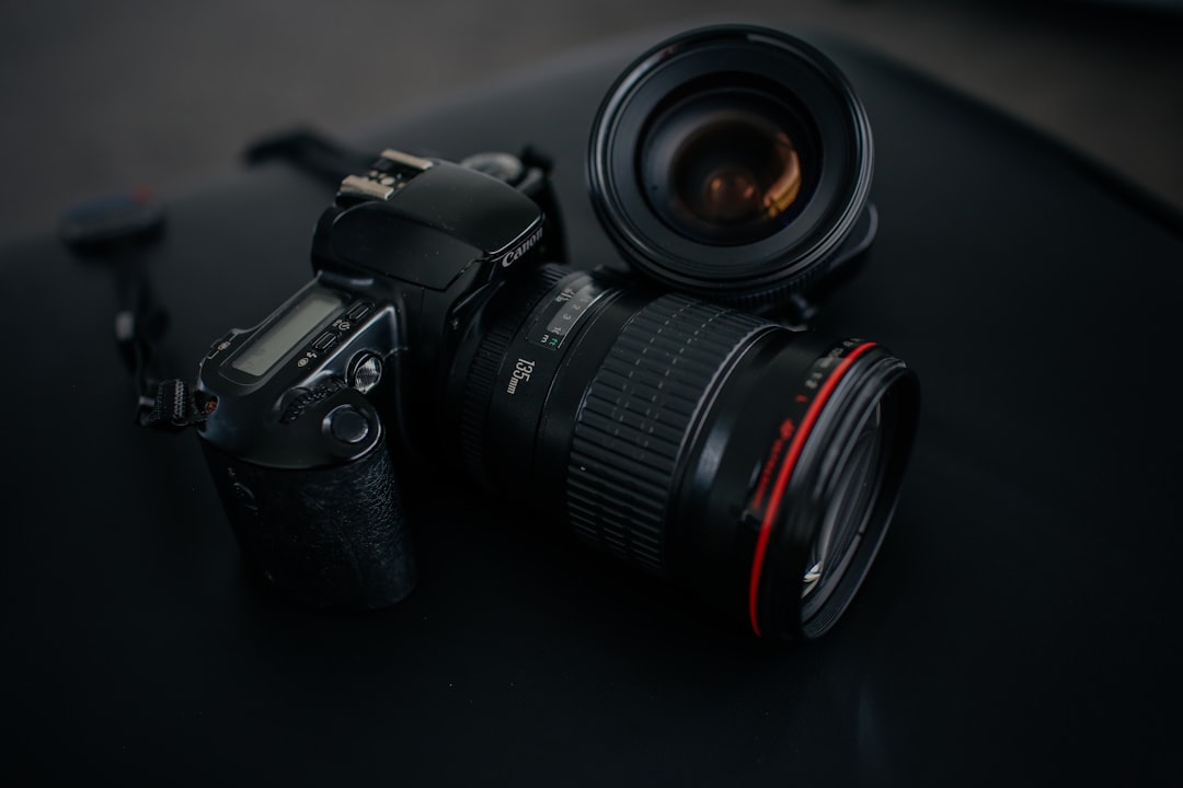 black Canon DSLR camera beside camera lens, Canon camera 135mm lens