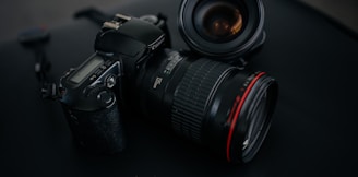 black Canon DSLR camera beside camera lens