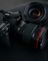 black Canon DSLR camera beside camera lens