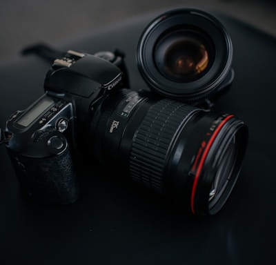 black Canon DSLR camera beside camera lens
