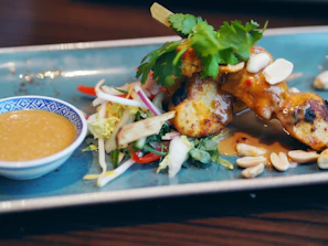 Grilled skewers of marinated chicken glazed with a sweet soy sauce, served with fresh greens