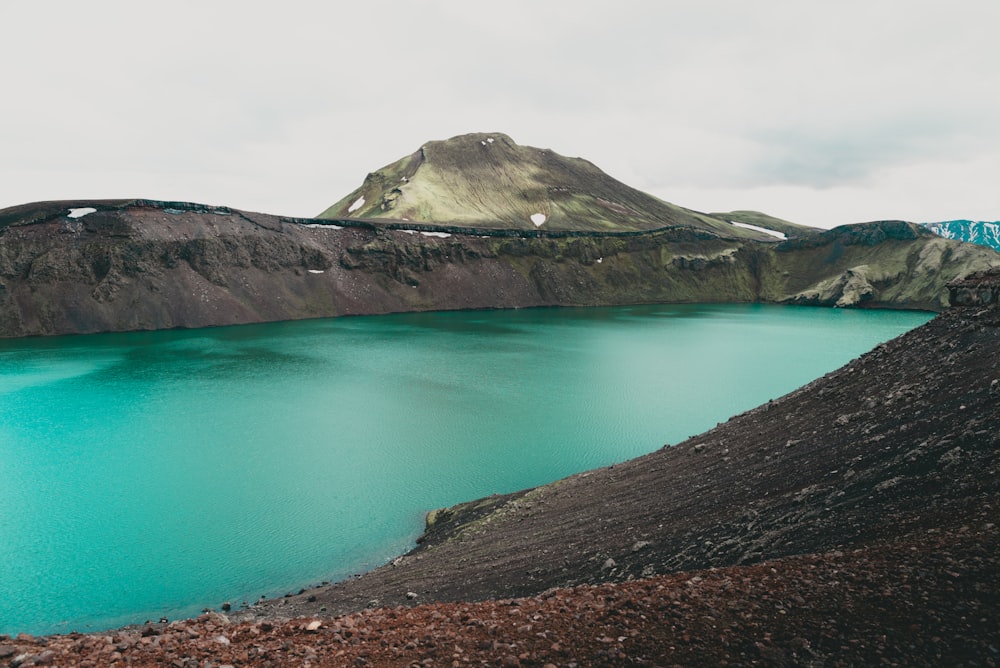 lake surrounded by mountains at daytime