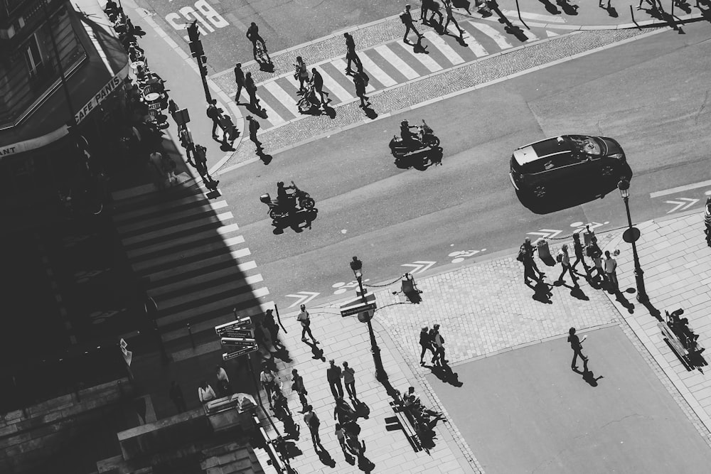 grayscale photography of group of people crossing streets