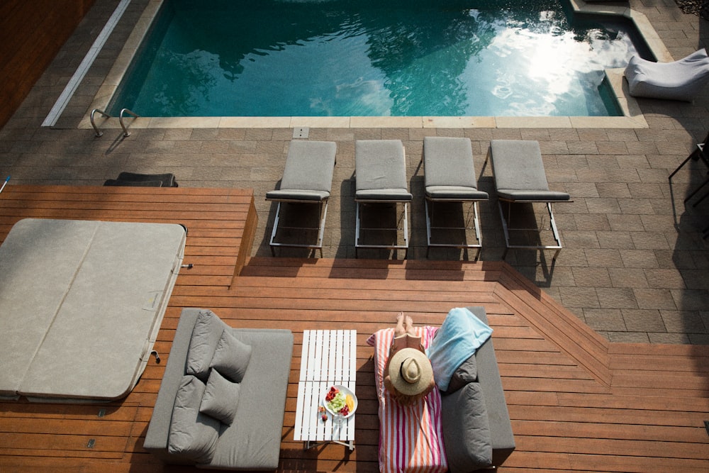 four gray loungers near pool