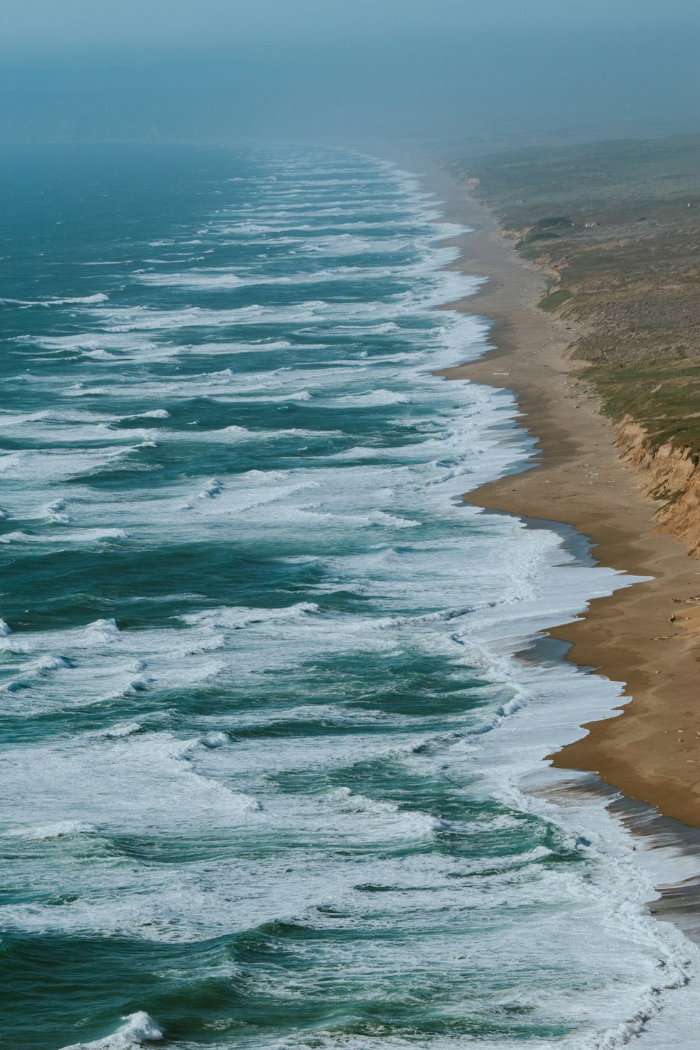 aerial photography of ocean waves hitting shore