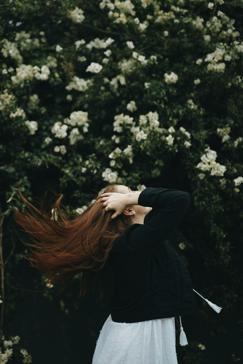 woman holding her hair near bougainvillea plant