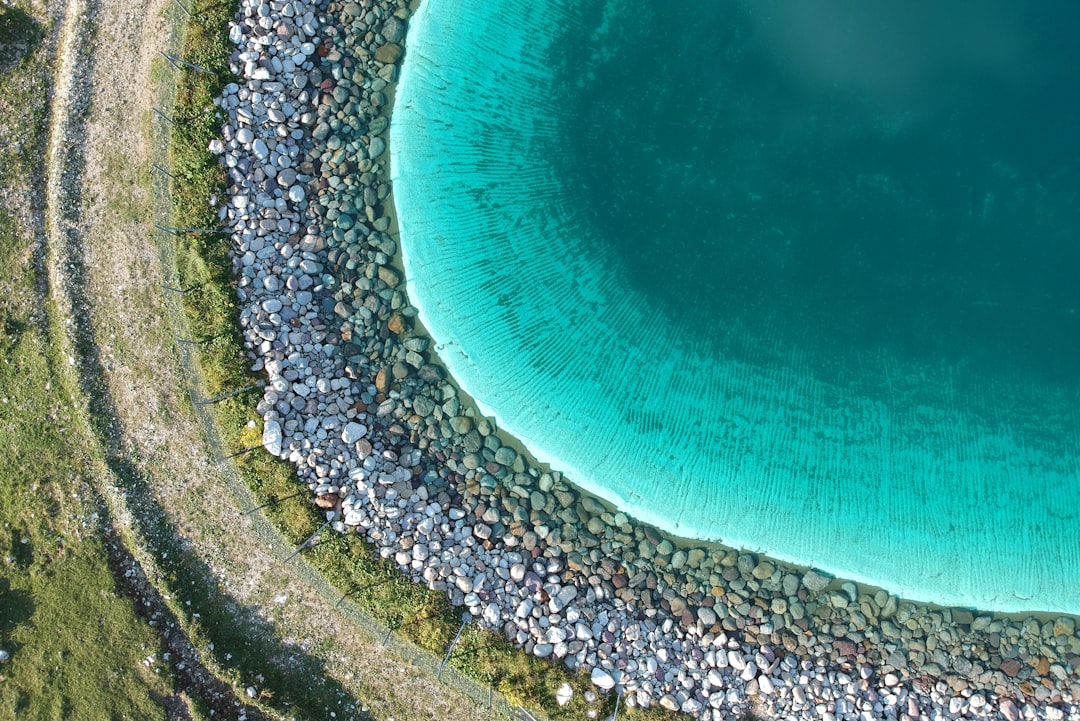 aerial photography of body of water surrounded with stones during daytime