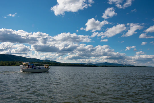 A vibrant boat cruising near lush green islands under a clear blue sky.