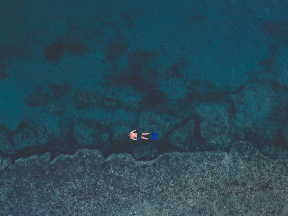 hombre flotando en el cuerpo de agua con aletas de natación