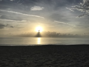 Sunrise over João Pessoa beach with warm golden light illuminating the shore.