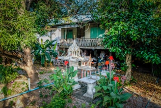 A charming traditional Japanese wooden house with a modern twist, surrounded by lush greenery.