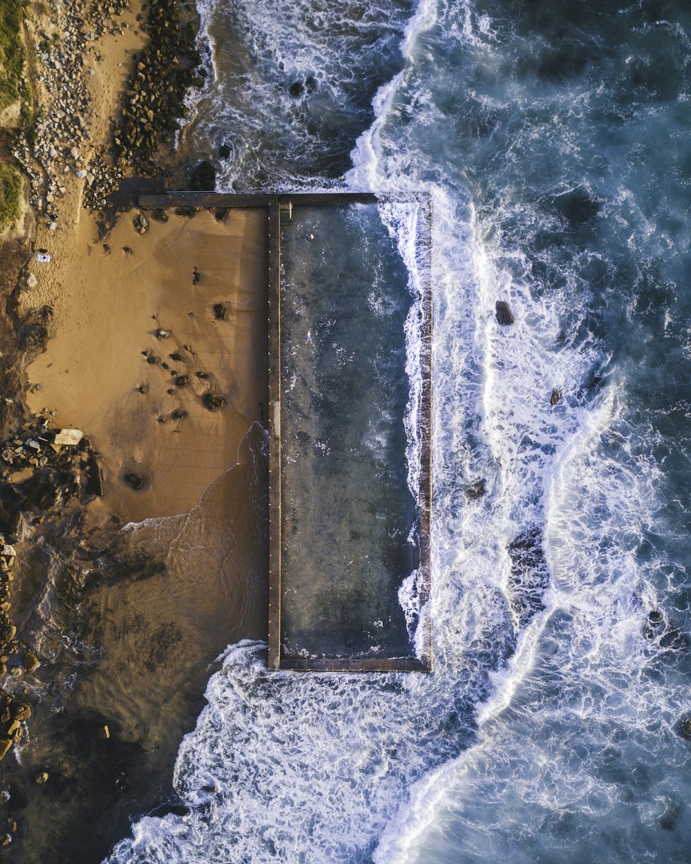 Luftaufnahmen von Meer, das tagsüber auf Sand trifft