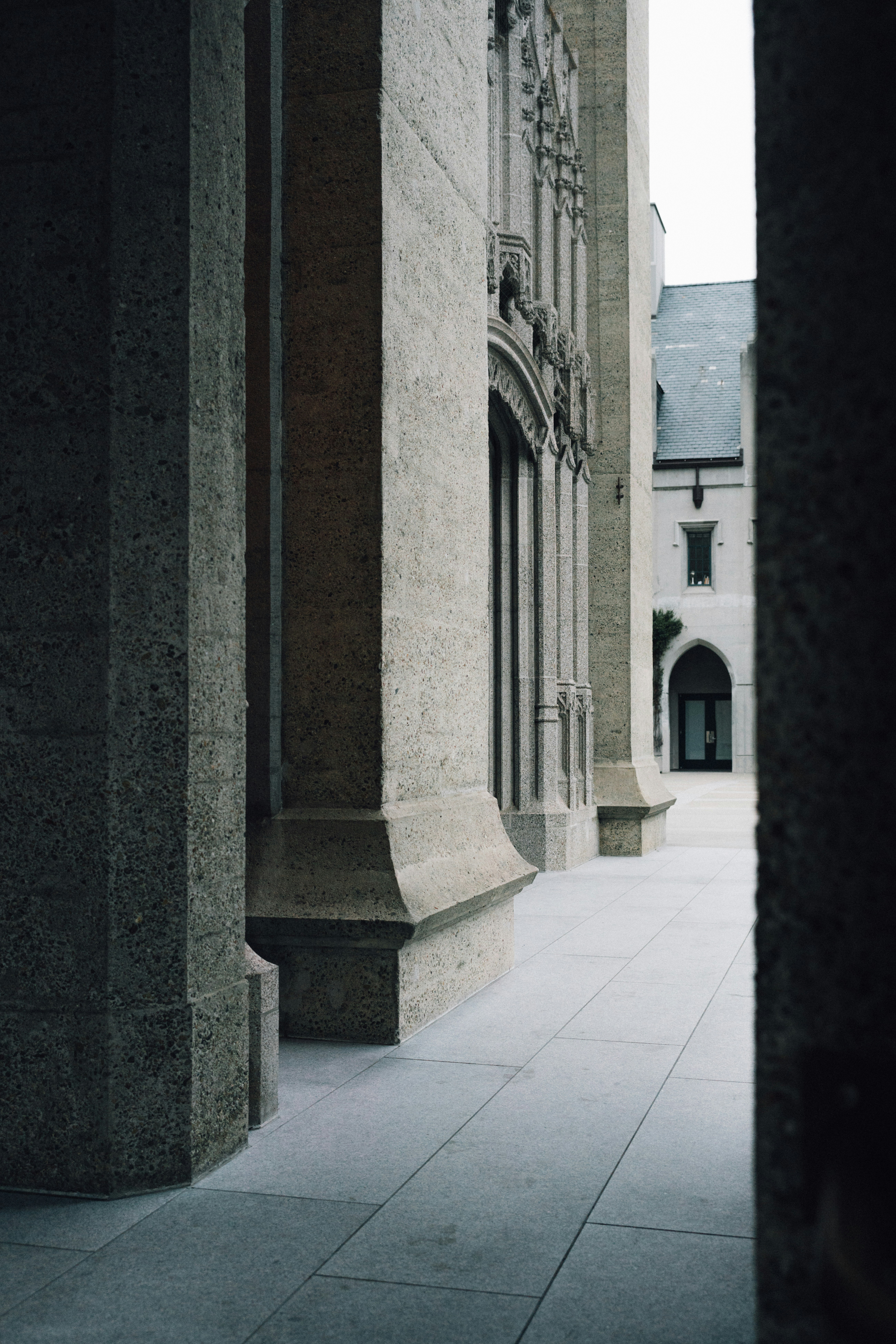 A stone building with columns and a clock tower in the background photo ...