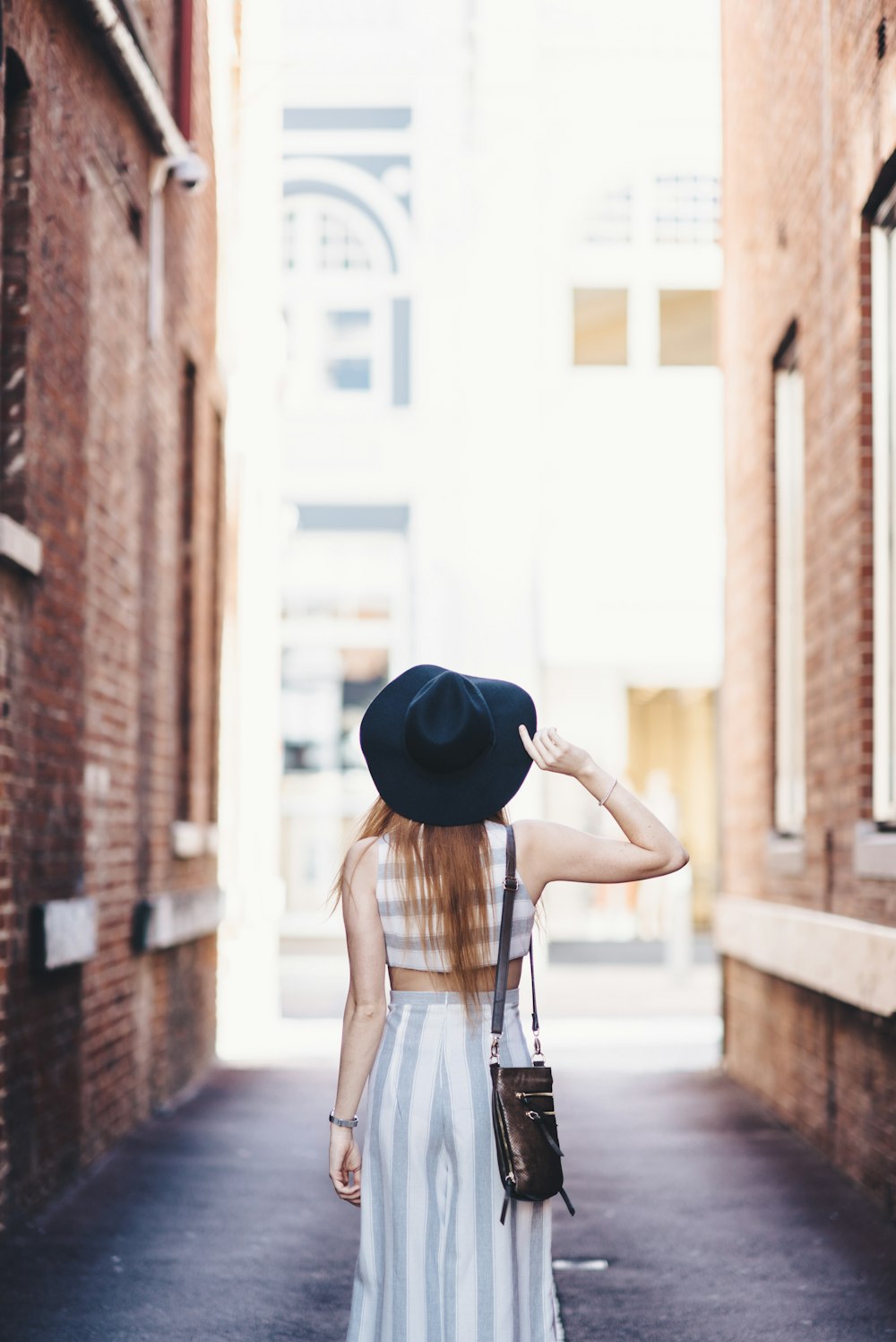 帽子をかぶって小道に立つ女性