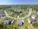 Aerial view of a newly developed suburban neighborhood with green lawns.