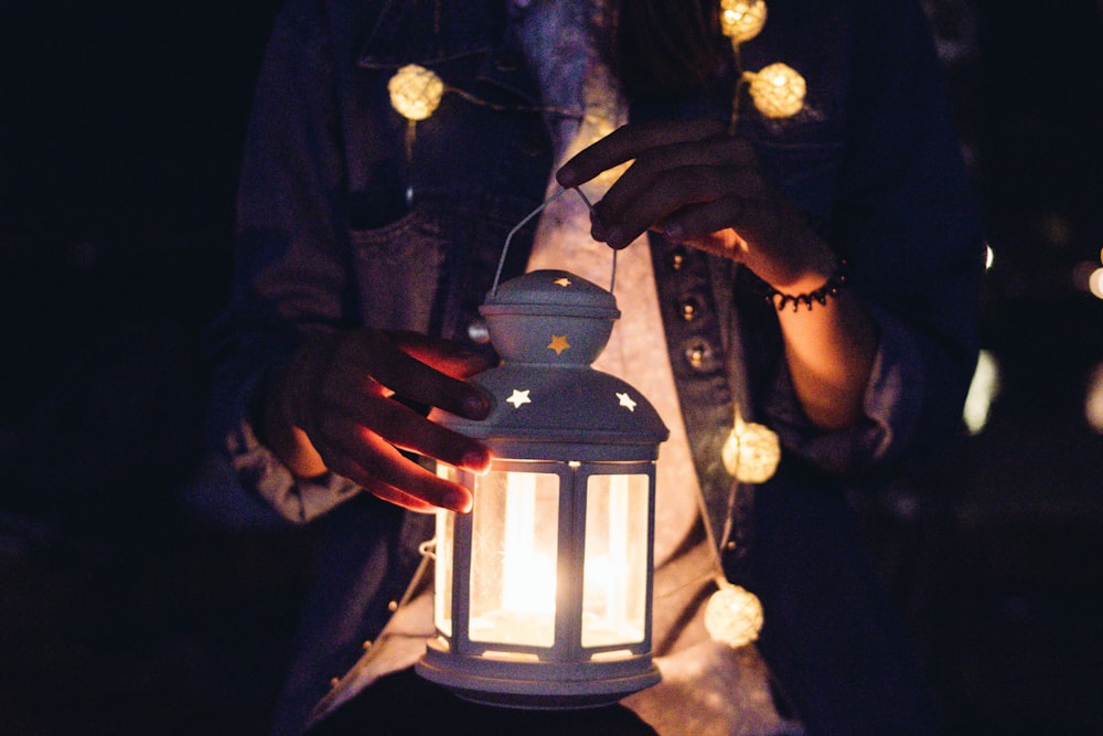 person holding candle lantern