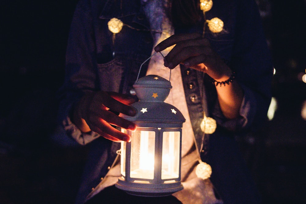 persona sosteniendo linterna de vela