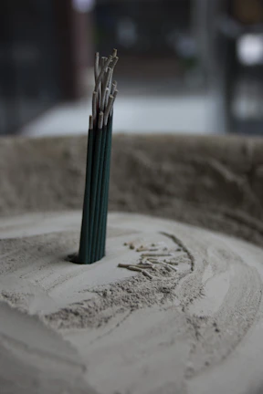 Close-up of traditional incense sticks arranged neatly on a wooden table with soft natural lighting