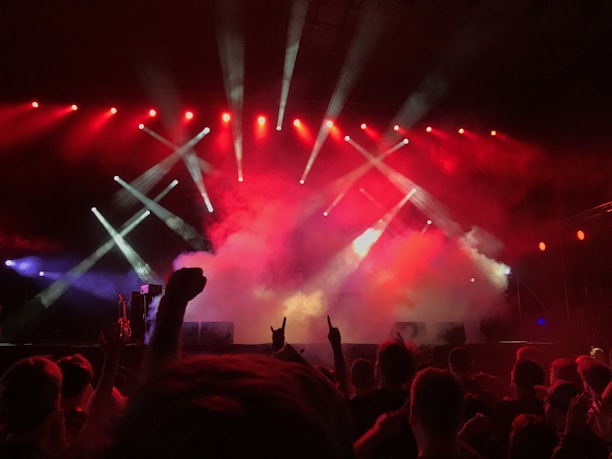 A lively event scene with a diverse crowd enjoying a live show under bright lights.