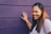 woman wearing purple shirt touching the wall