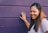 woman wearing purple shirt touching the wall