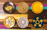 Hand-painted decorative plates arranged on a rustic wooden table.