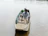 A smiling man standing beside his boat on calm waters with a Momentum electric motor visible.