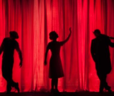 silhouette of three performers on stage