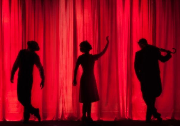 silhouette of three performers on stage