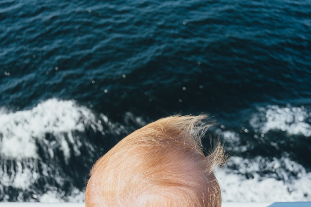 a baby looking at the water from a boat