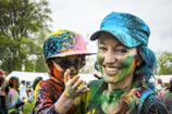 woman carrying child on color run