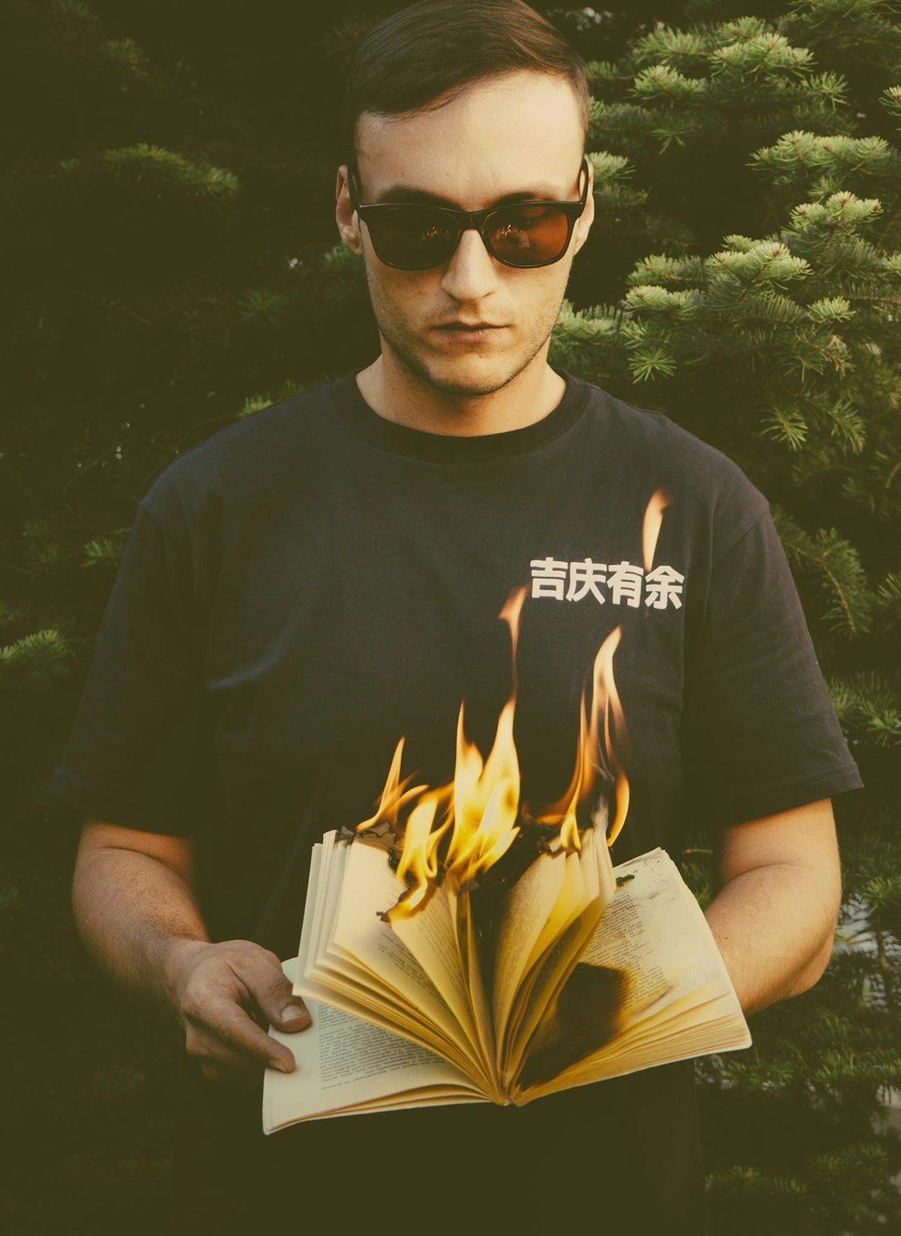 燃え盛る本を手にして立つ男