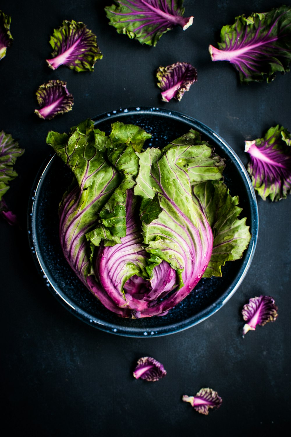 Légumes violets et verts dans un bol noir