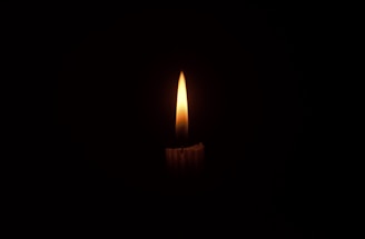 A gentle candle flame flickering softly, representing hope and inspiration.