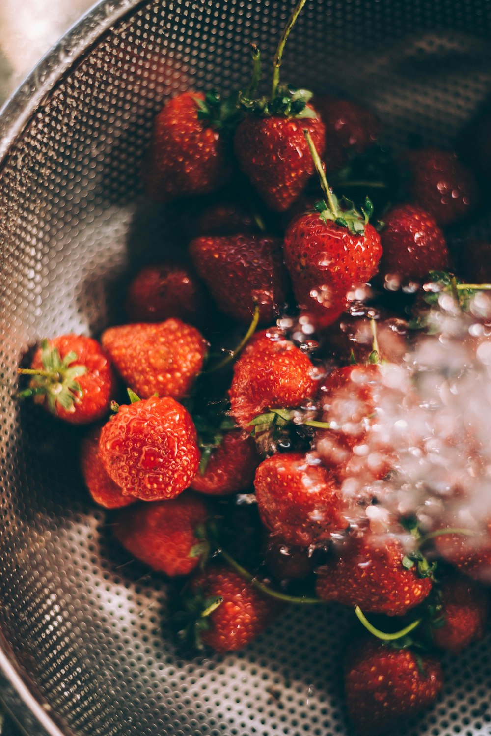 ripe strawberries on gray steel strainer