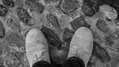 Close-up of elegant shoes on cobblestone pavement with soft natural light