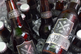 Selection of Modelo, Tecate, and Corona beer cans and bottles chilled on ice in a rustic basket.