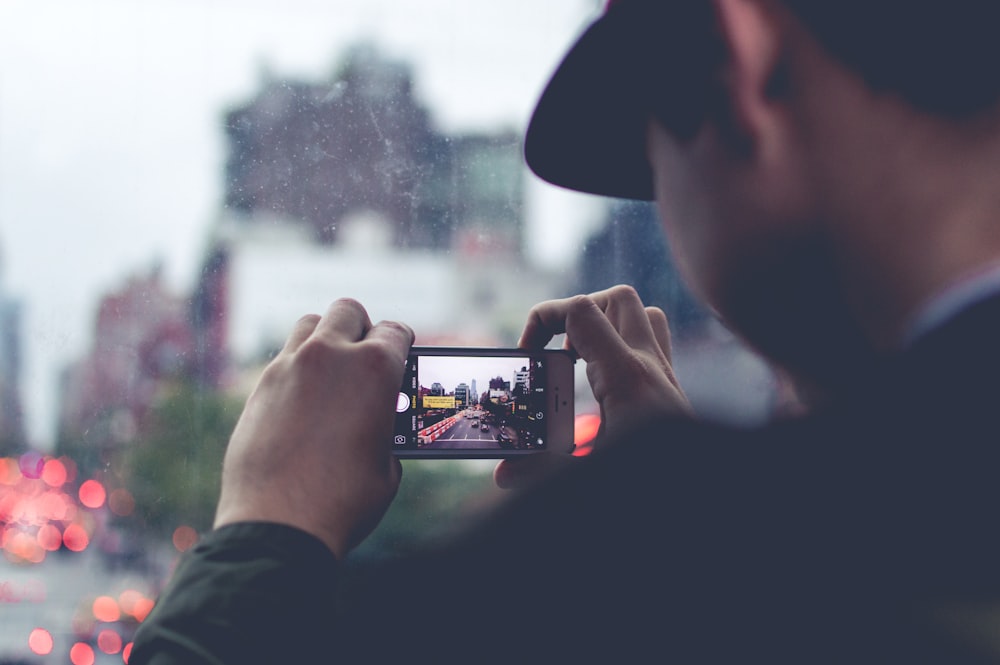 uomo che utilizza la fotocamera dello smartphone