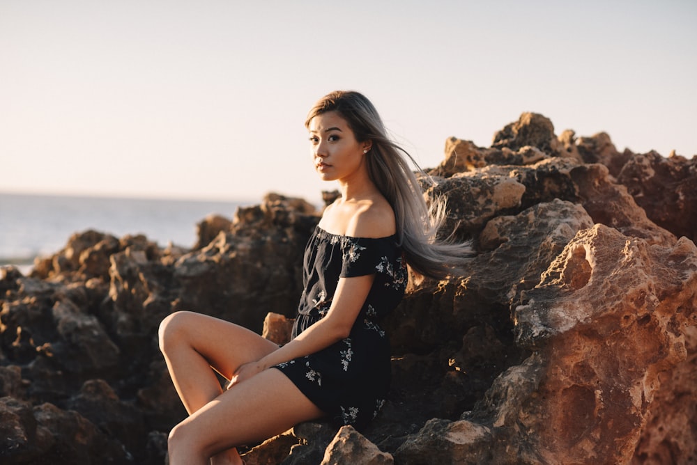 woman sitting on rock