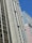 A cityscape featuring tall buildings with modern architectural designs against a clear blue sky. One of the buildings prominently displays a sign that reads 'CESAR BUSINESS'. The structures have a variety of rectangular windows, and one building has a beige and cream façade.