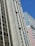 A cityscape featuring tall buildings with modern architectural designs against a clear blue sky. One of the buildings prominently displays a sign that reads 'CESAR BUSINESS'. The structures have a variety of rectangular windows, and one building has a beige and cream façade.