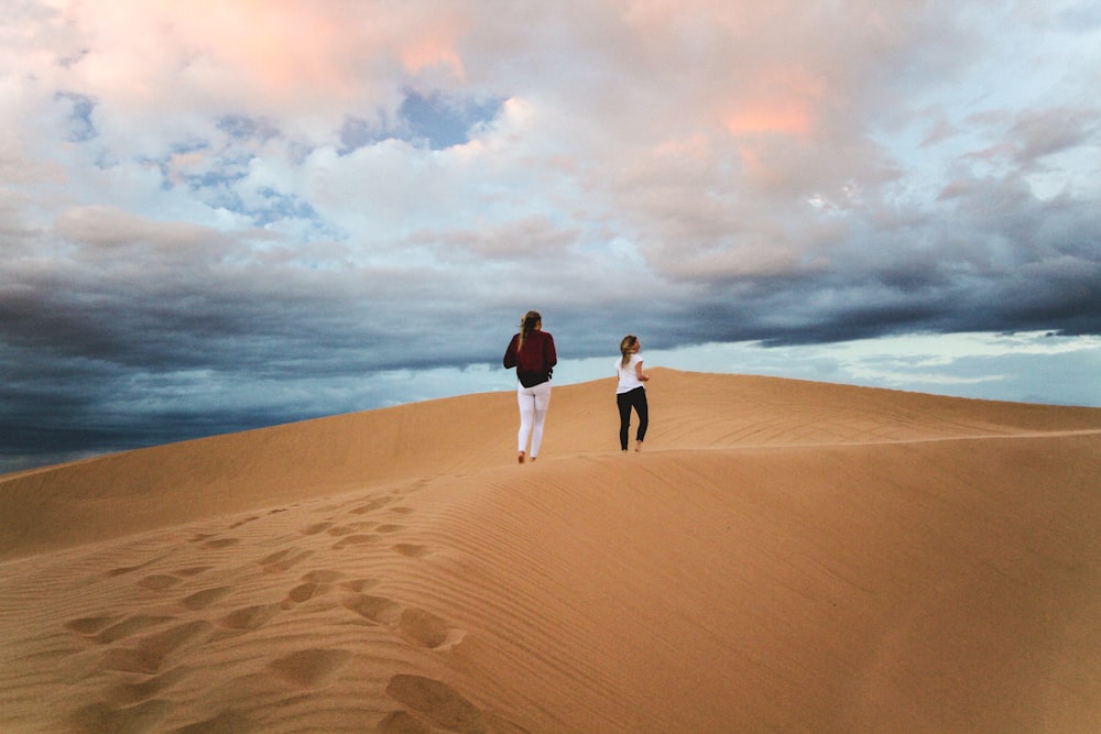 two women walking on desert