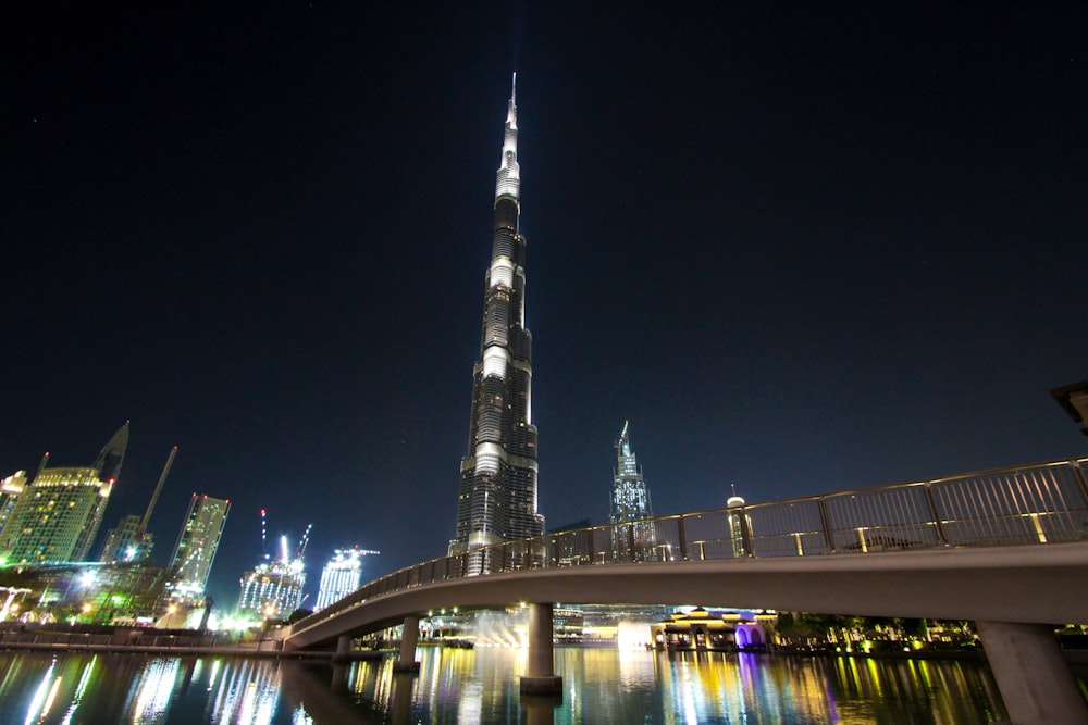 skyline photography of bridge near high-rise buildings at nighttime