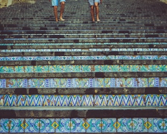 two person's stepping on stairs