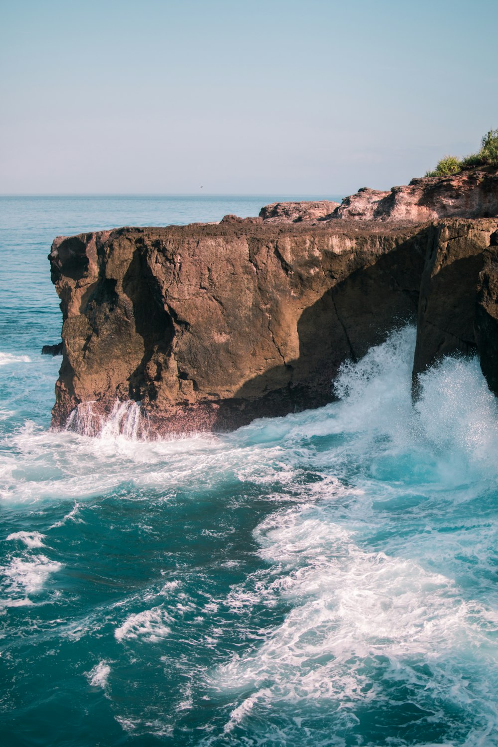 a rocky cliff sticking out of the ocean