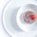 A round dessert sits in a white bowl, topped with a single fresh red strawberry. The dessert appears glazed, with a smooth white sauce pooling around it.