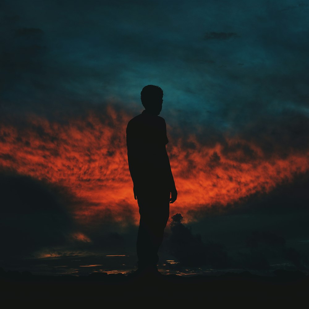 silhouette photography of man standing on ground
