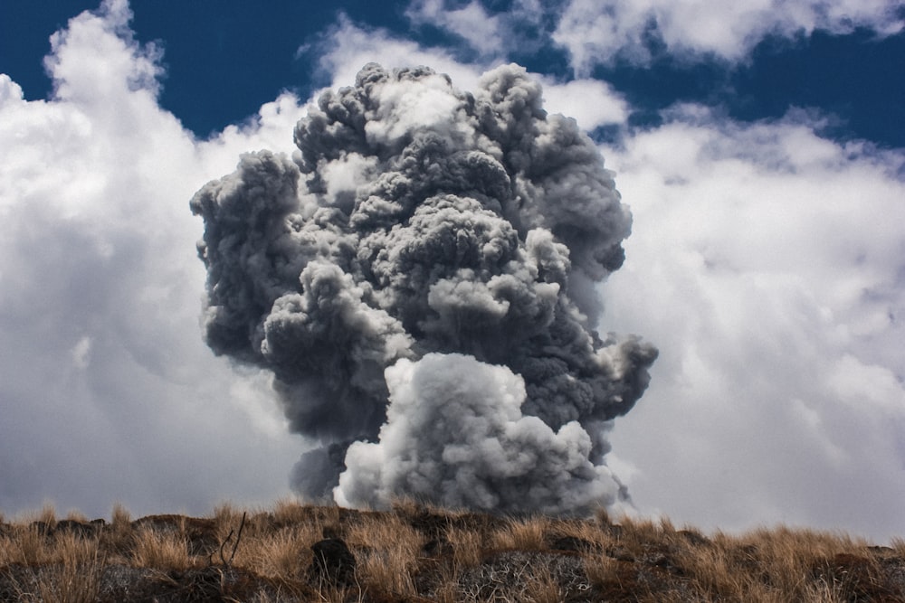 black smoke burst in brown open field at daytime